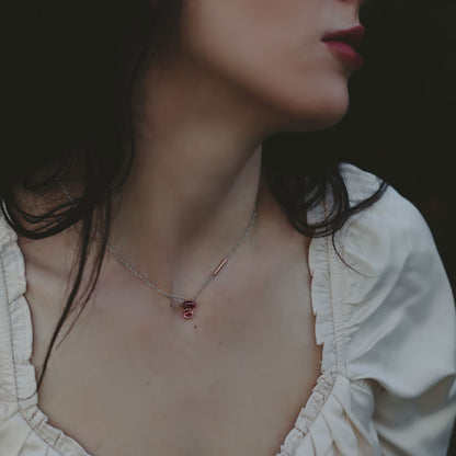 Close-up of a woman wearing a delicate necklace in two tone white and rose gold with a small pink tourmaline and pink garnet rose gold pendant