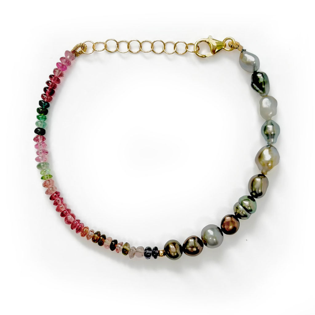 A beaded necklace with a 14K solid gold chain extender and clasp, featuring a left side of small tourmaline gemstone beads in pink, green, and red, and a right side of larger iridescent tahitian keshi pearls in gray, green, and brown tones.