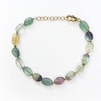 A multi-colored gemstone beaded necklace with a gold-tone clasp and extender chain, displayed on a clean white background.
