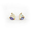 Pair of earrings with opal and tanzanite gemstones accented by diamonds on a white background