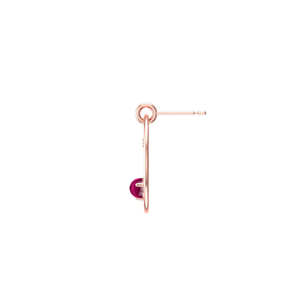 Rose gold hoop earring with a reddish pink garnet gemstone on a white background side view