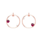 Rose gold hoop earrings with reddish pink garnet gemstones on a white background