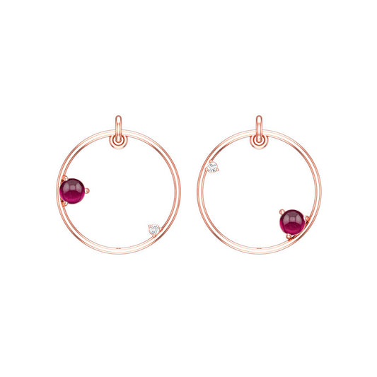 Rose gold hoop earrings with reddish pink garnet gemstones on a white background