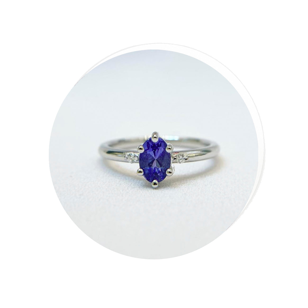 white gold ring with a purple tanzanite gemstone on a white background